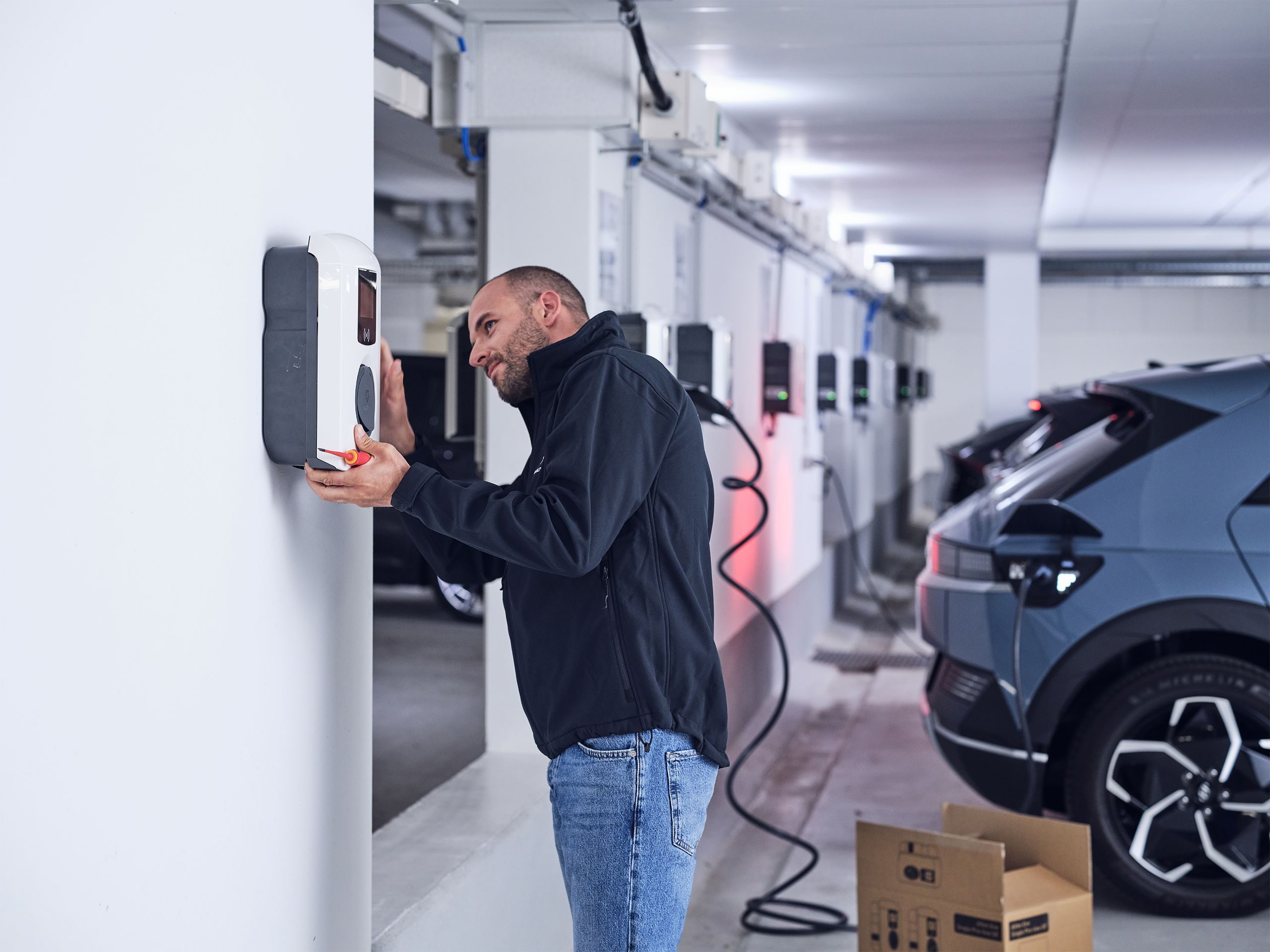 Elektriker montiert Wallbox in Tiefgarage