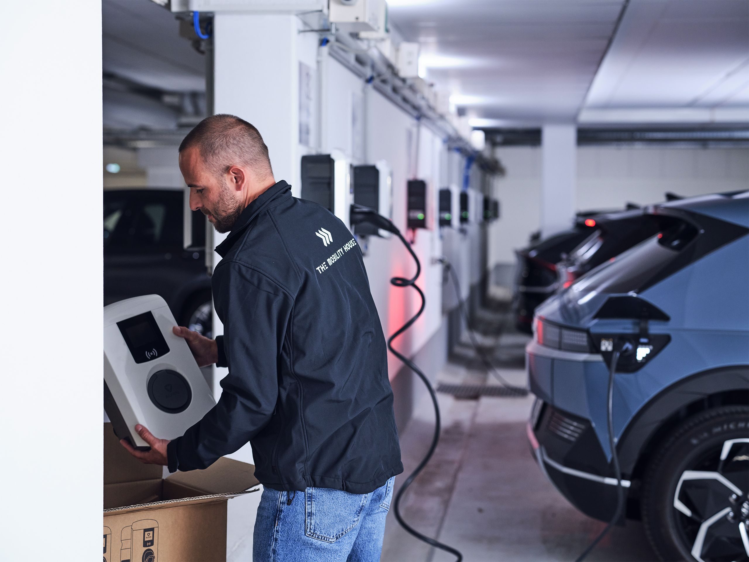 Elektriker montiert Wallbox in Tiefgarage