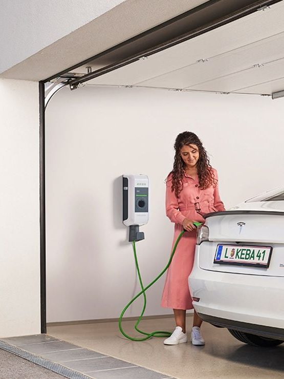 Frau steckt Tesla an die Wallbox