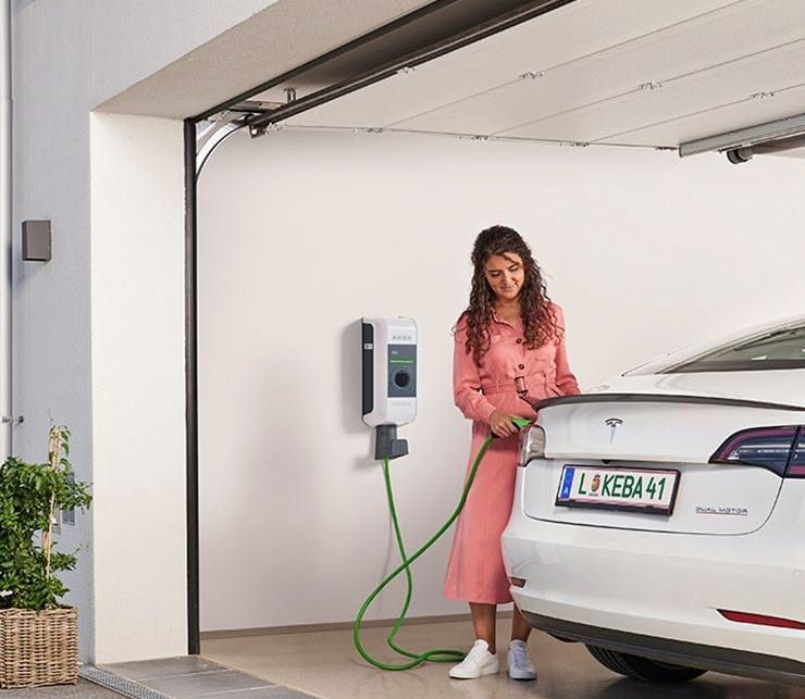 Frau steckt Tesla an die Wallbox