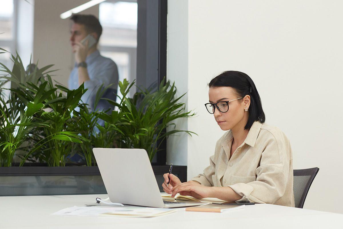 Junge Frau arbeitet im Büro am Laptop
